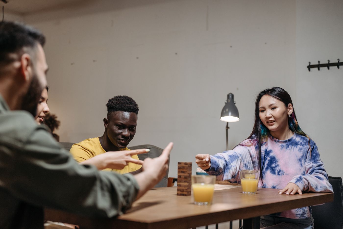 Friends gathered around a table with a wooden stacking game