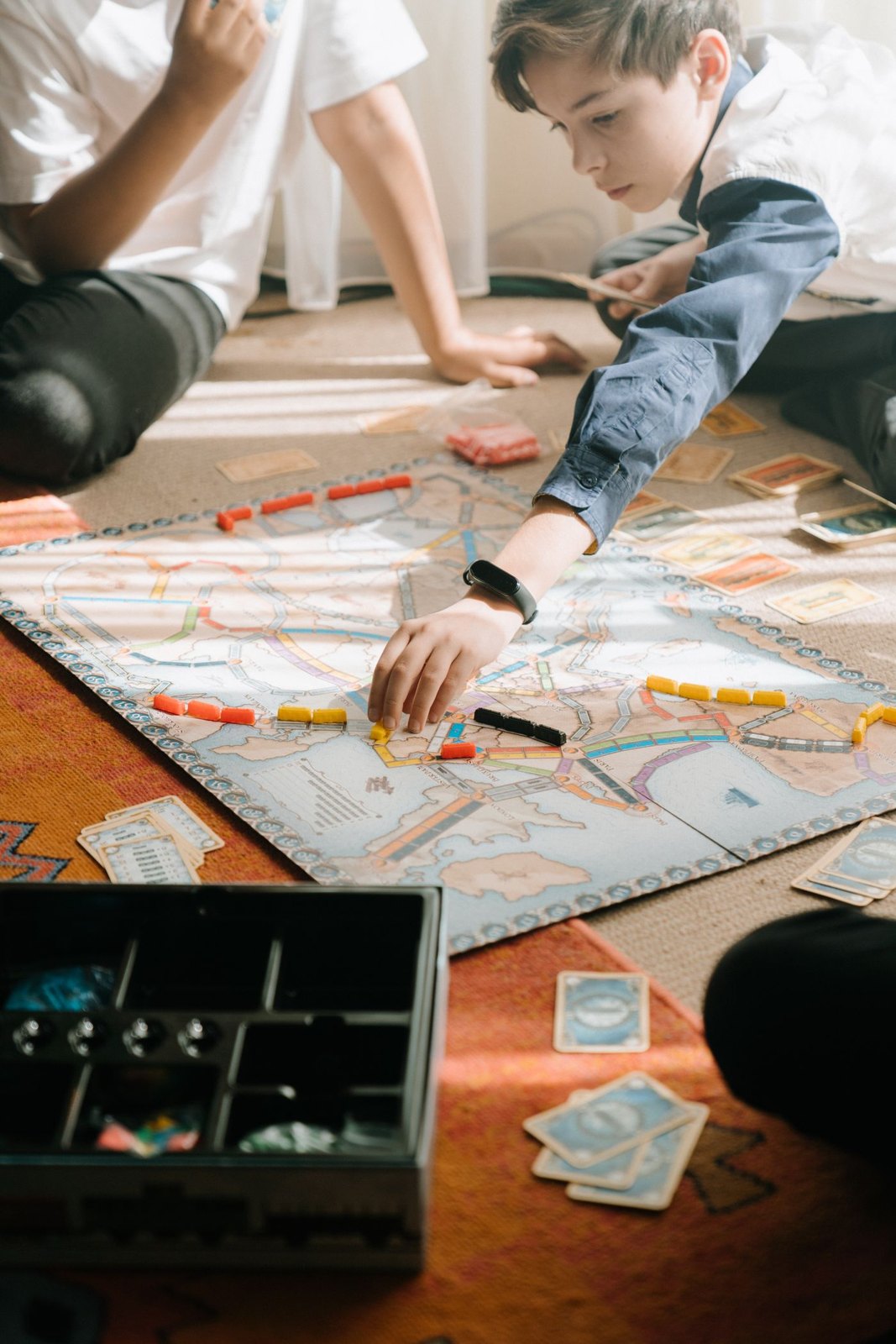 Young players arranging train pieces on a map board