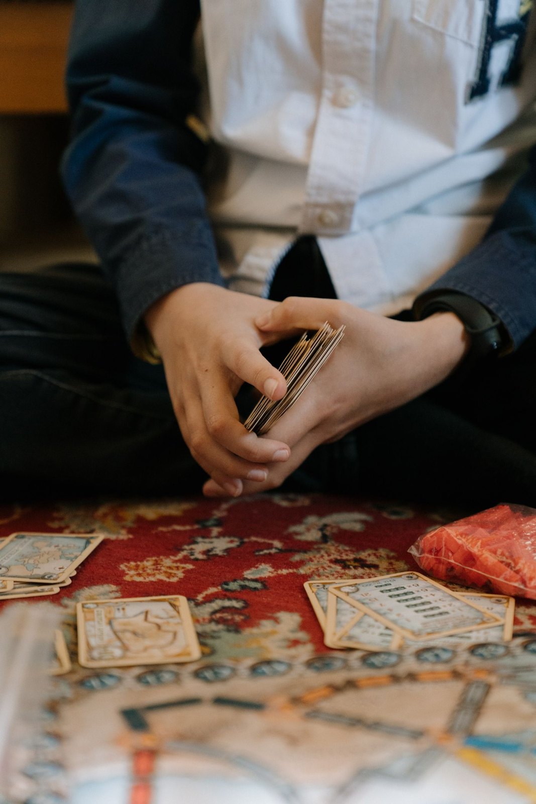 Hands shuffling a deck above a game board