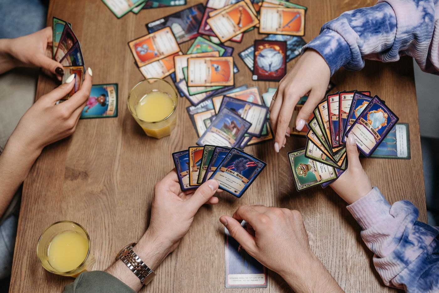Illustrated cards spread across the centre of a table