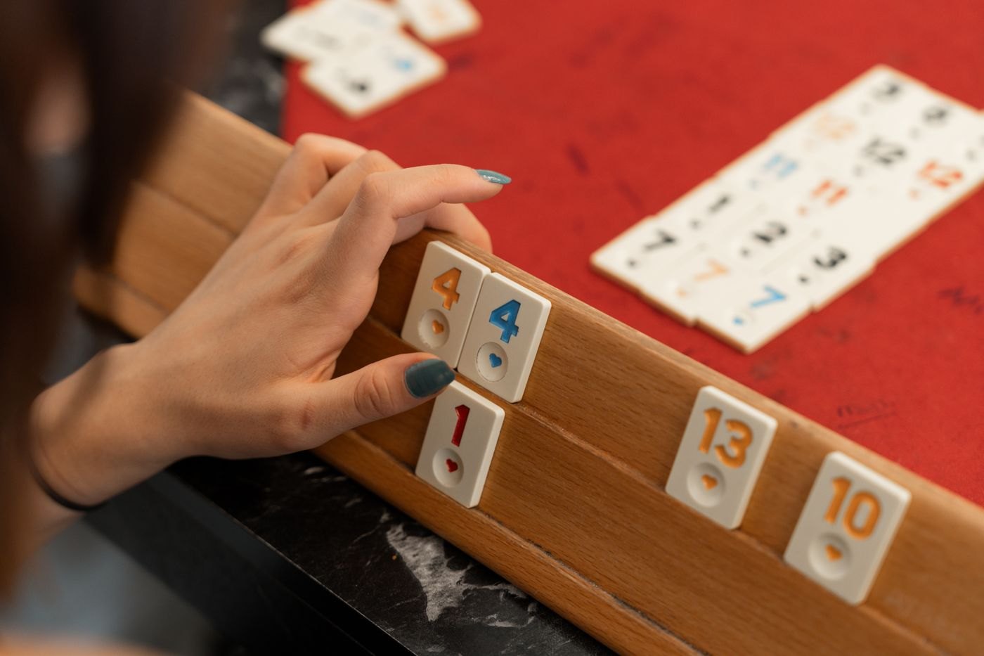 A player considering numbered tiles on a rack