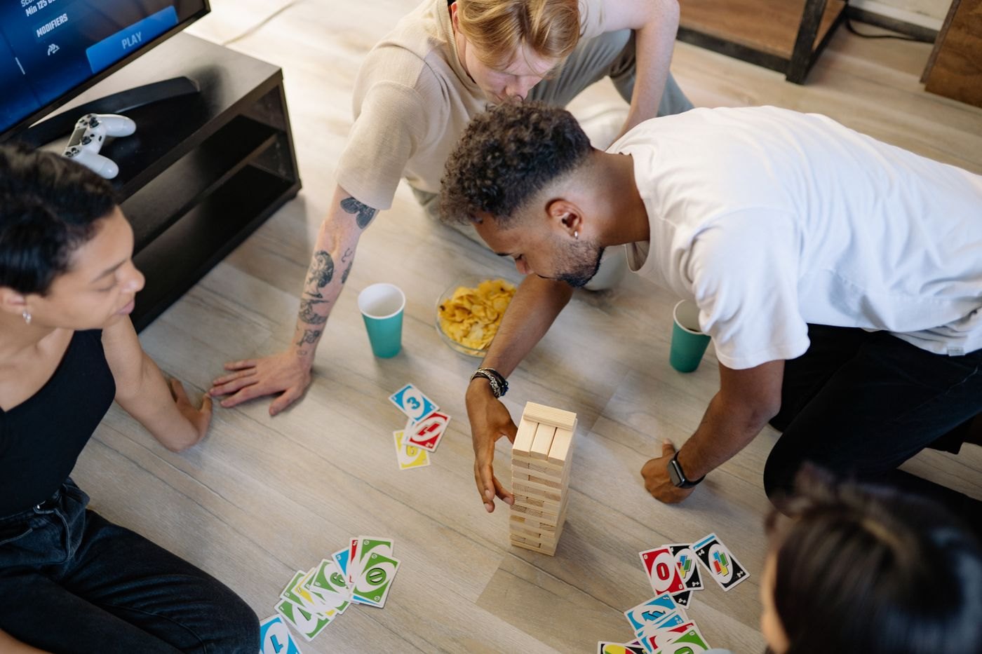 A group playing cards and a wooden stacking game