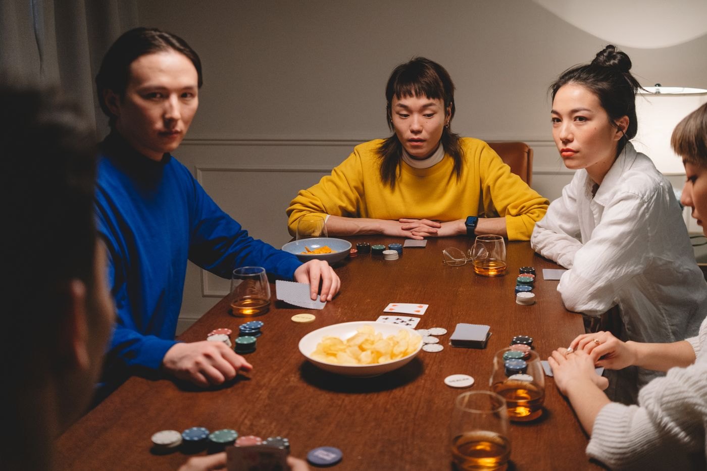 Friends seated around a table with cards and tokens