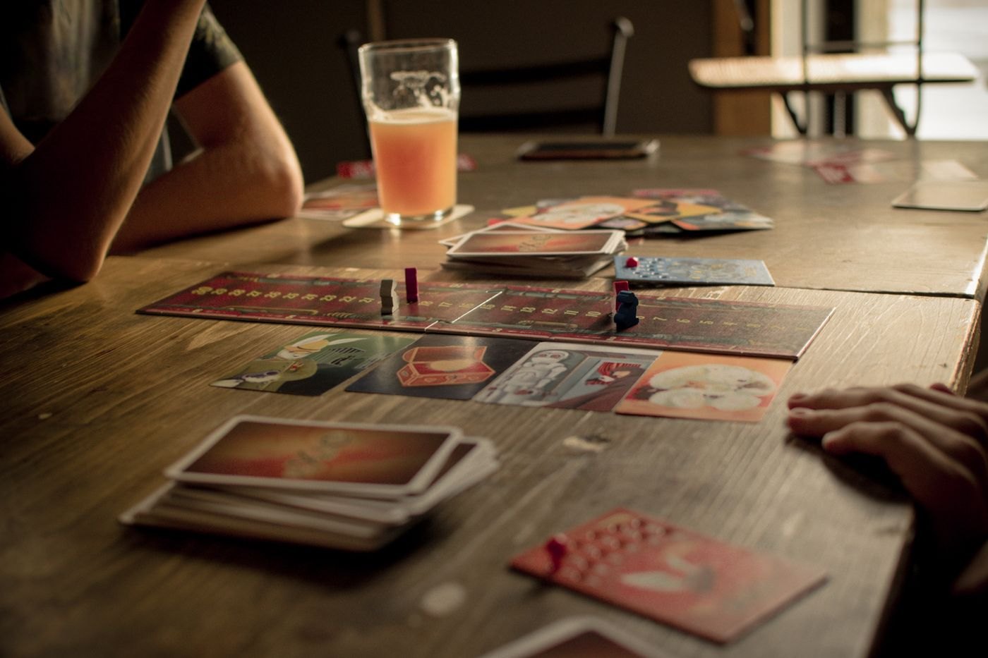 Game cards left laid out across a shared wooden table
