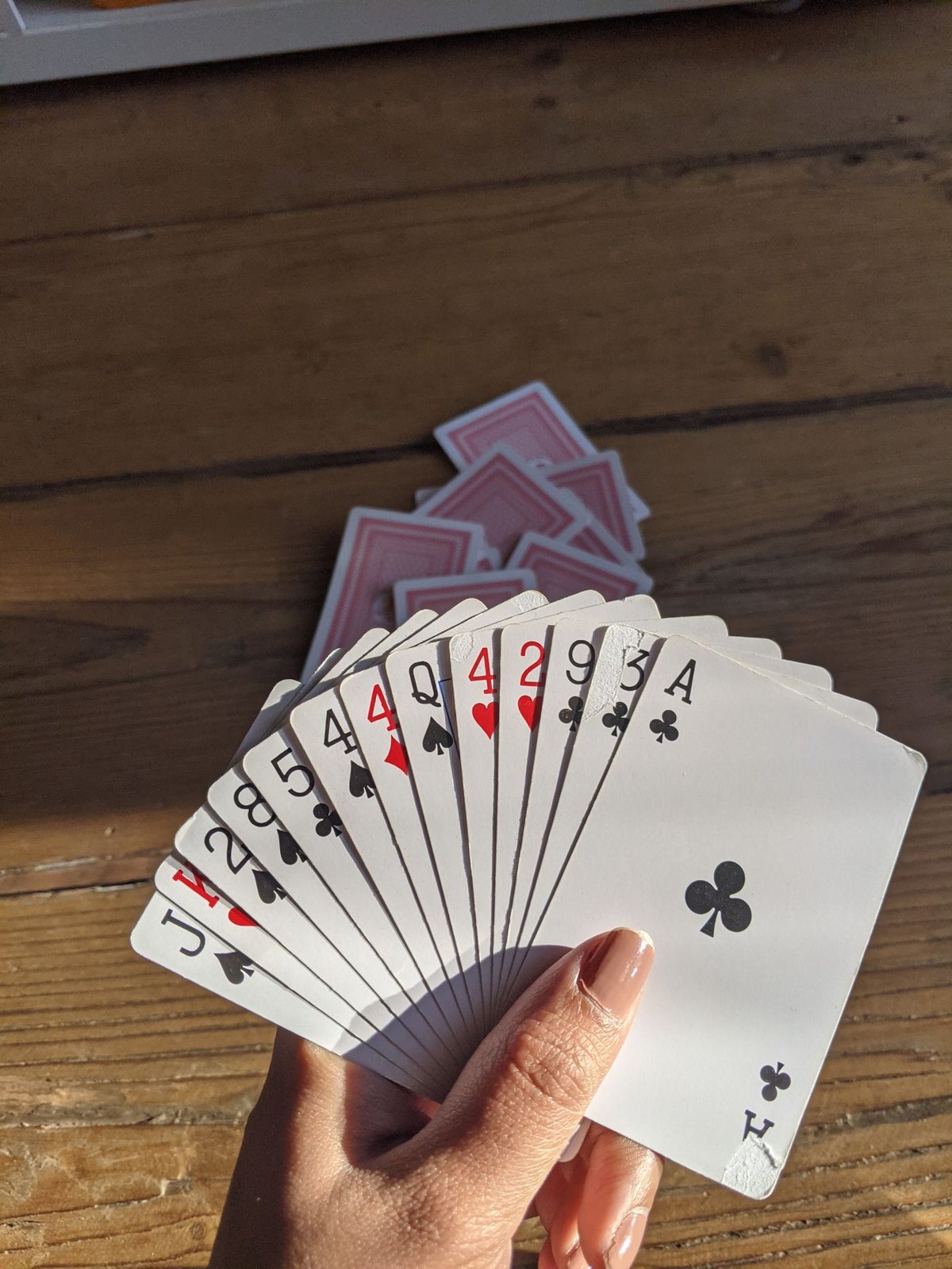 A fan of standard playing cards held above a table