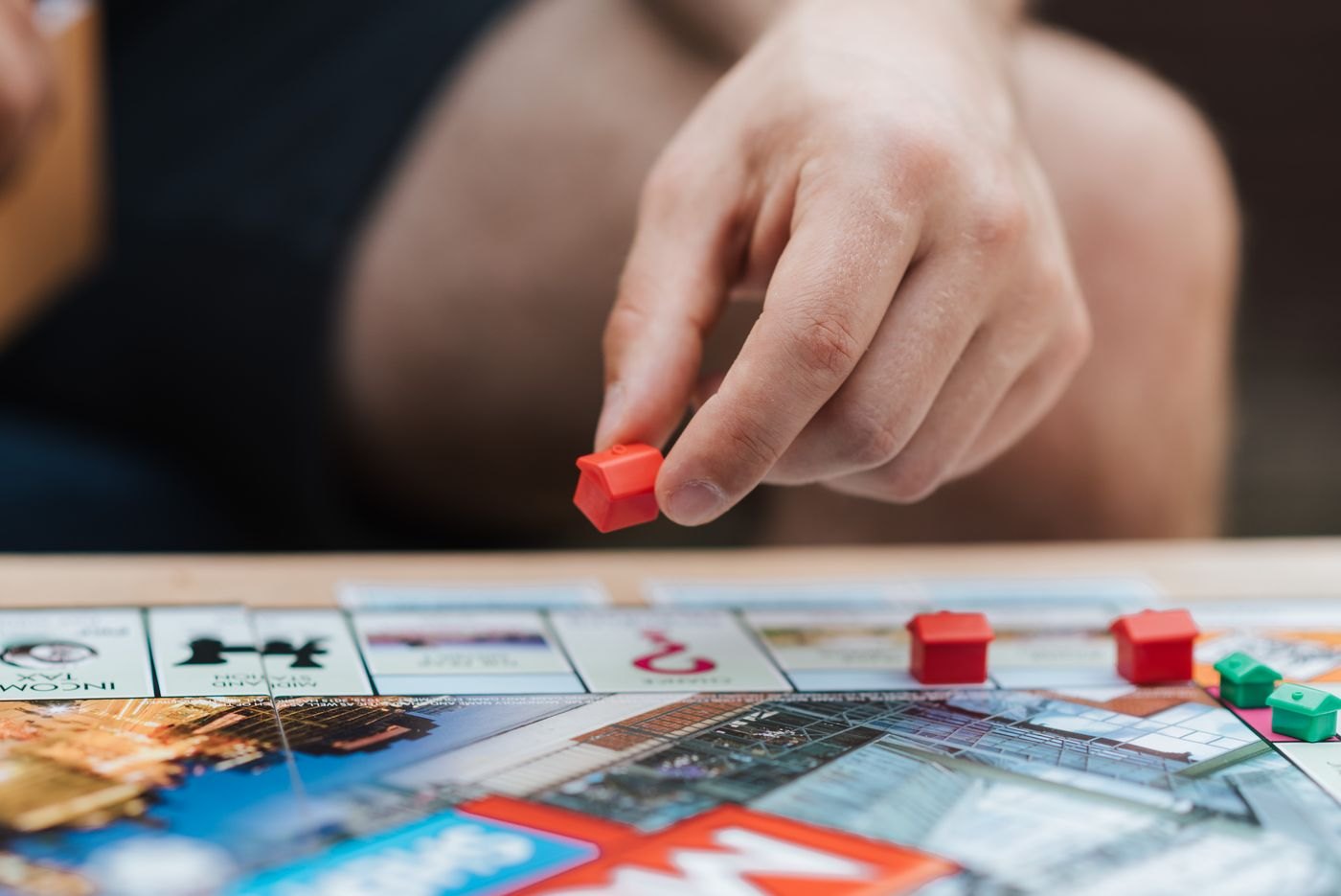A hand lifting a small red piece above the board