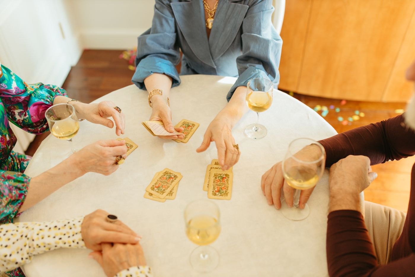 Players holding cards around a shared table