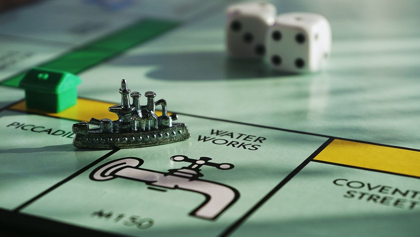 A small metal game piece beside a white die